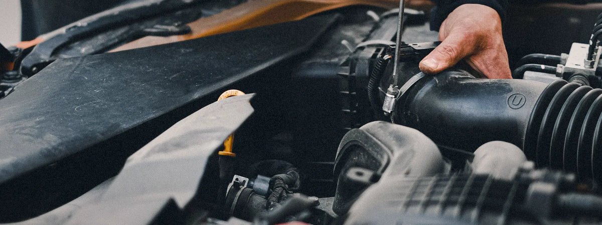 Hands servicing a car engine